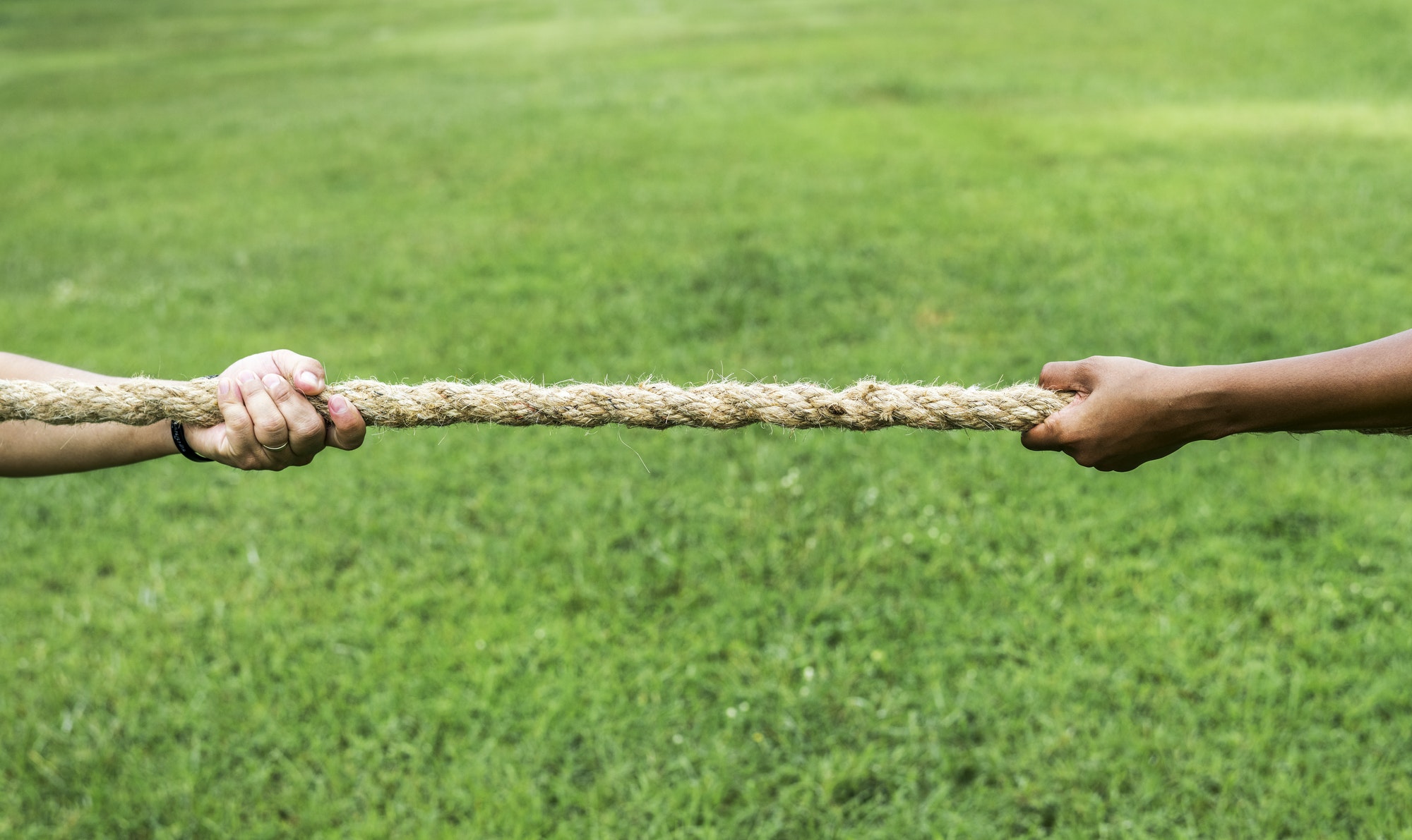 Closeup of hand pulling the rope in tug of war game