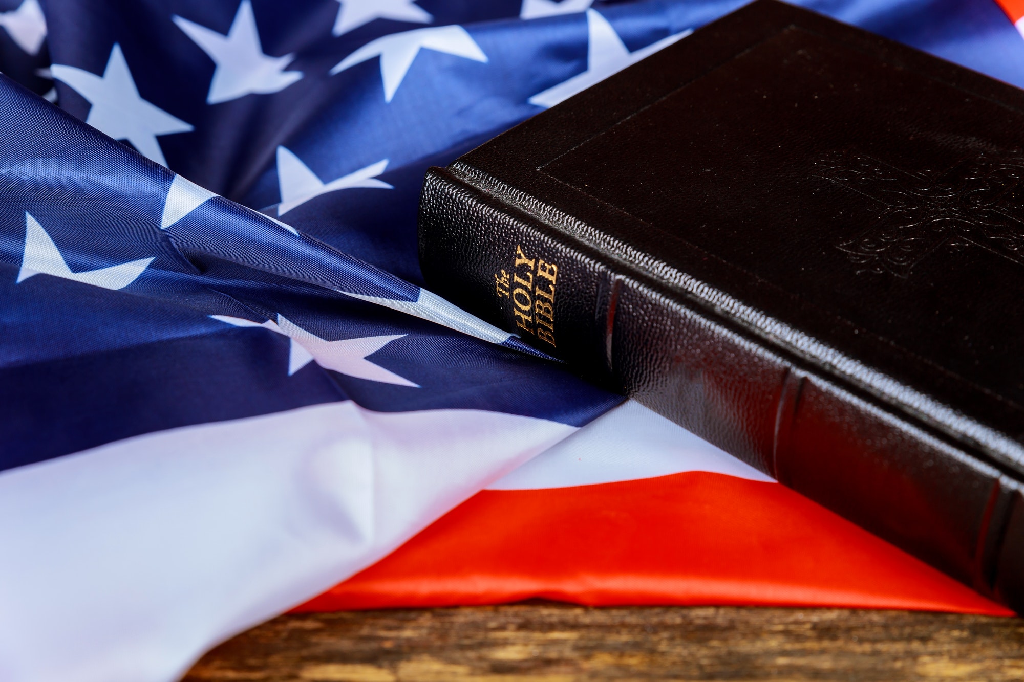 United States Flag and Holy Bible on Distressed Wood Background